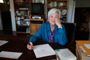Ellen Bryant Voigt writing at a desk