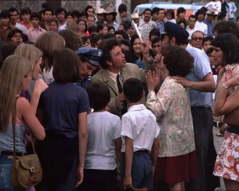 Columbo standing in a crowd of people.